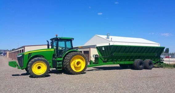 Farm tractor with a hydraulic bale wagon in an Idaho field
