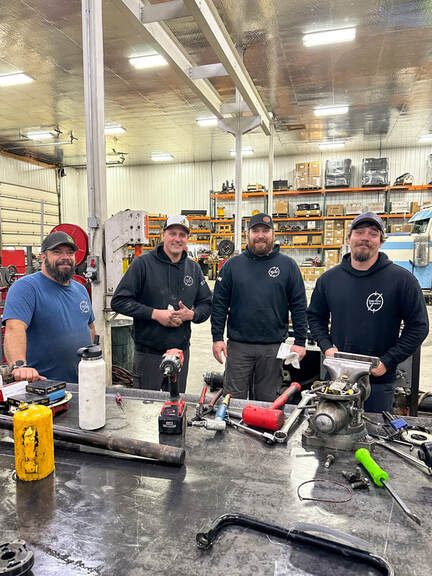 Snake River Hydraulics technicians working on hydraulic equipment in the shop